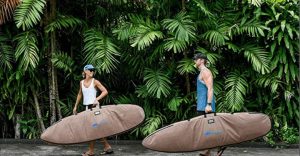 two surfers carry surfboards