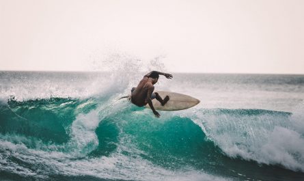 man rides a wave on a surfboard