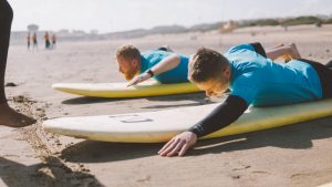 instructor teaches students to surf on the board