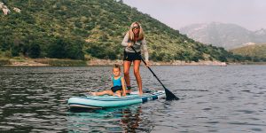girl with a child floats on a surfboard