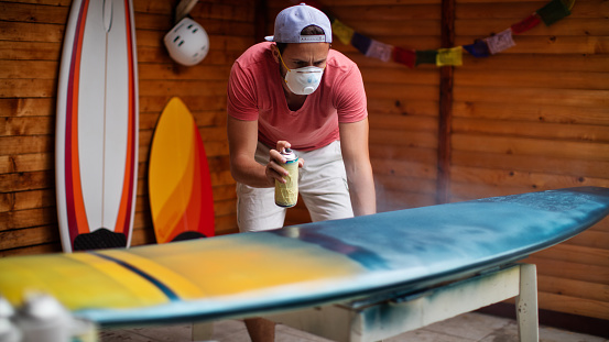 Young man working in a surfboard workshop