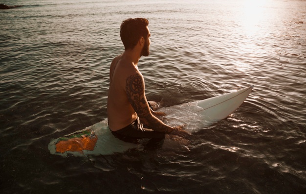 Man sitting on Quiver Killer surfboard