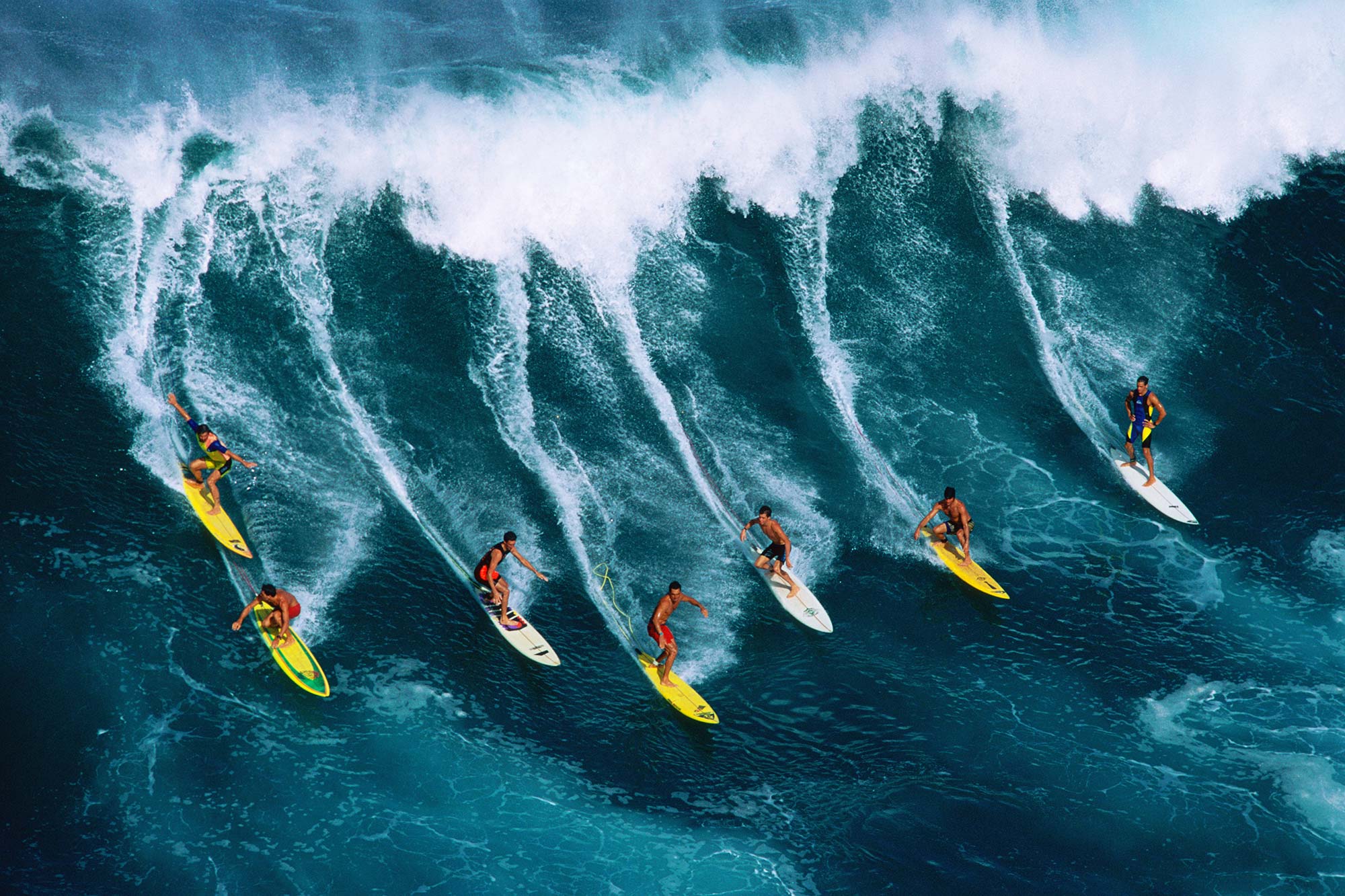 Seven surfers riding large wave