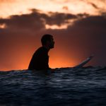 Why is it important to hold the surfboard correctly in the line-up