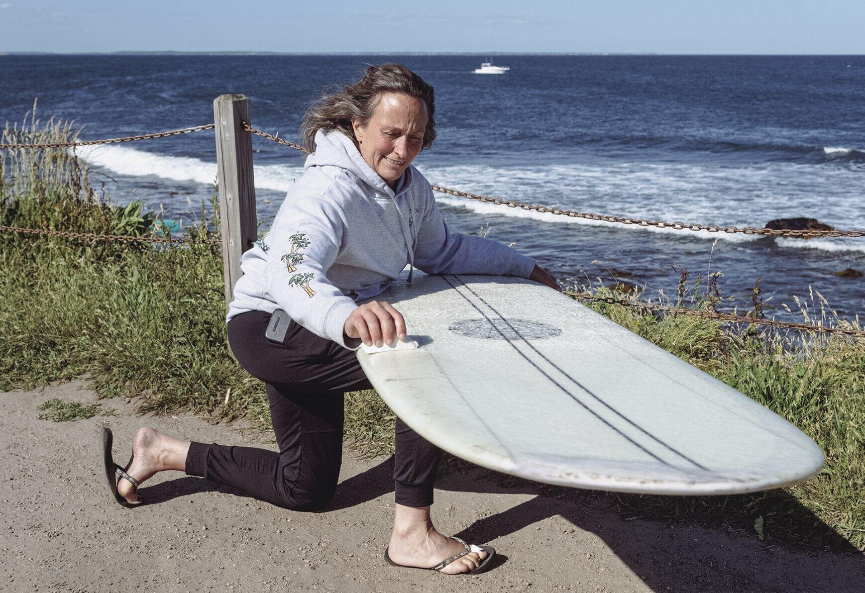 woman wipes a surfboard