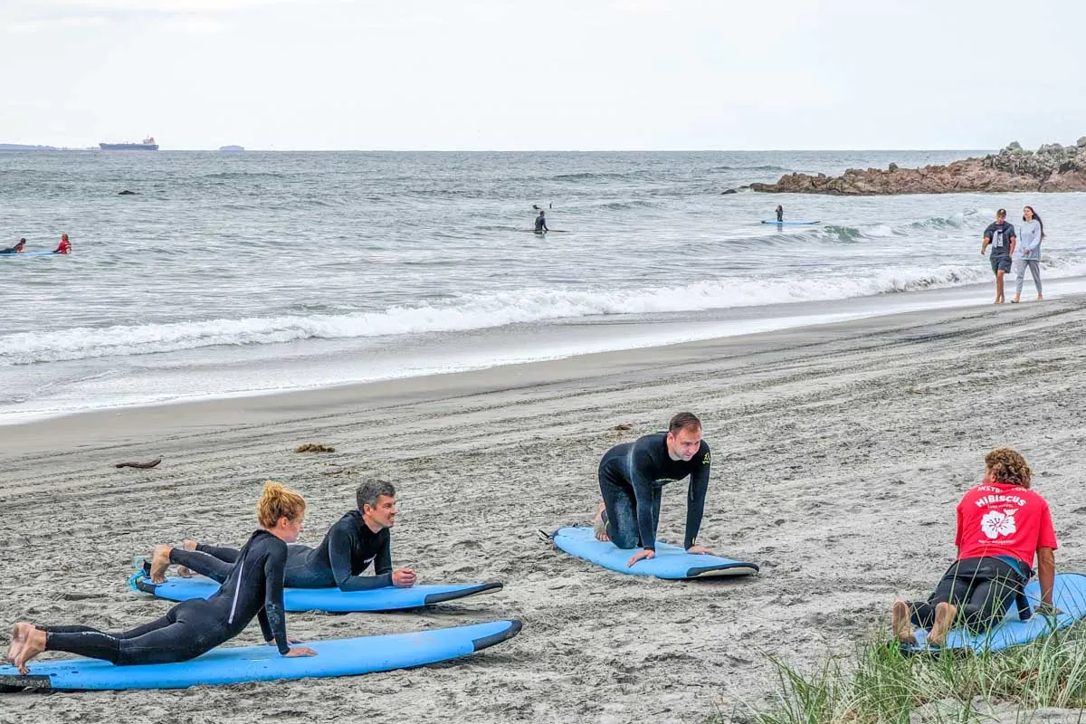 A-group-of-people-learn-to-surf-in-Mount-Maunganui