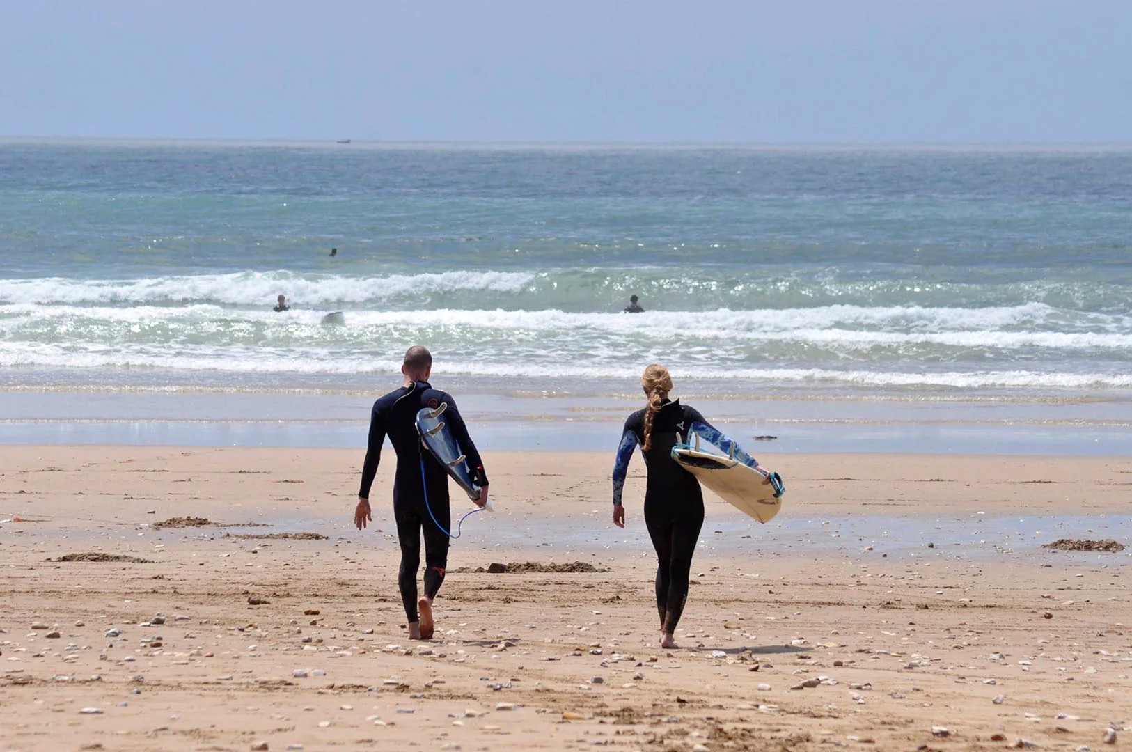 man and woman with surfboard
